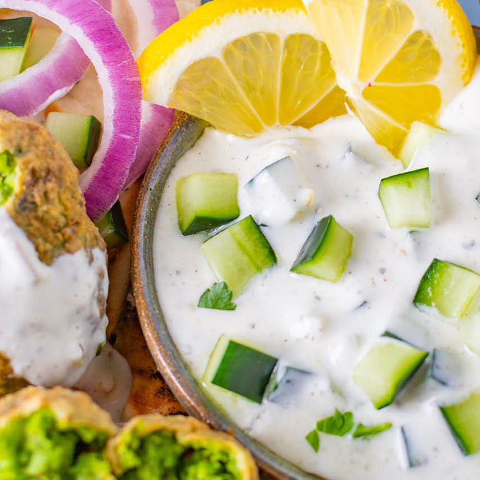 Greek Tzatziki Dip garnished with diced cucumber served with green pea falafel