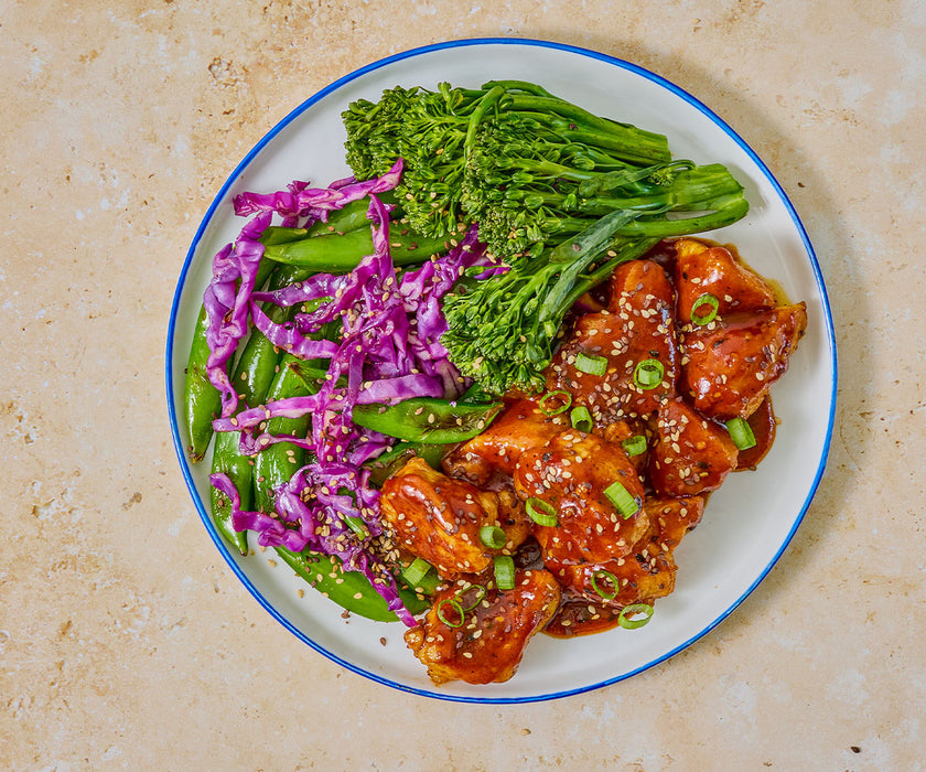 overhead image of a plate of bourbon chicken, snap peas, and broccoli. 