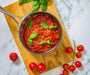 Overhead image of a pot of made classic marinara sauce with basil.