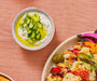 An overhead shot of a finished bowl of Greek Tzatziki dip with added dill and fresh cucumbers.